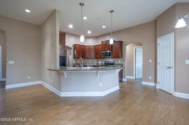a view of kitchen with kitchen island microwave and refrigerator