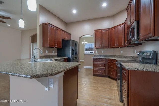 a kitchen with stainless steel appliances granite countertop a sink stove and refrigerator