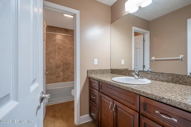 a bathroom with a granite countertop sink and a mirror