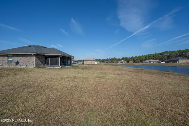 a front view of a house with a yard and lake view