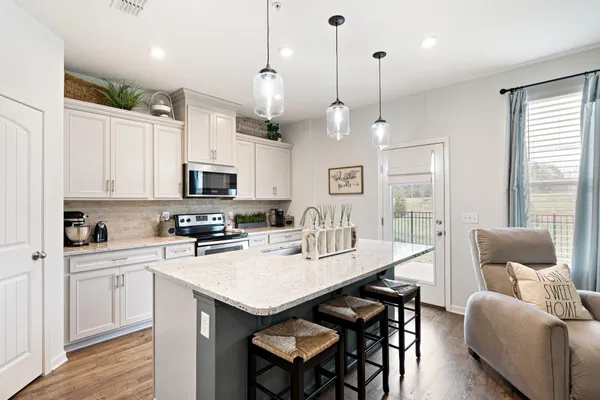 a large kitchen with kitchen island a sink appliances and a counter space