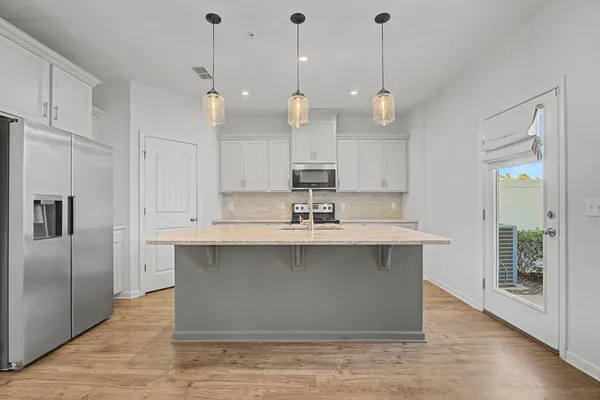 a kitchen with kitchen island a sink stainless steel appliances and cabinets