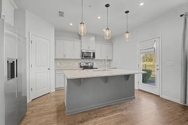 a kitchen with kitchen island a sink stainless steel appliances and cabinets