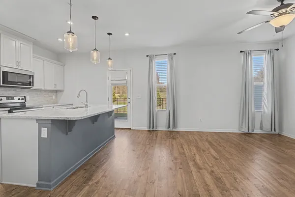 a living room with furniture a flat screen tv and a window