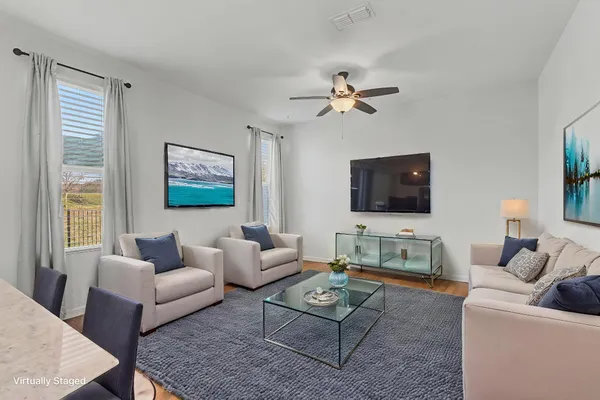 a view of a room with a ceiling fan and hardwood floor