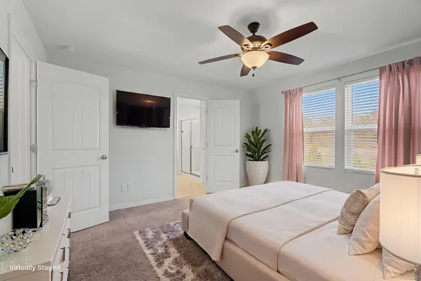 a view of an empty room with window and a ceiling fan