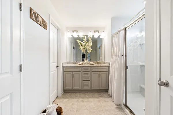 a bathroom with a double vanity sink mirror and a shower