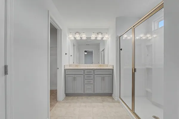 a bathroom with a granite countertop sink a mirror and a shower