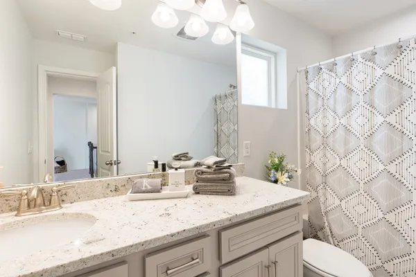 a bathroom with a granite countertop sink a toilet and a bathtub