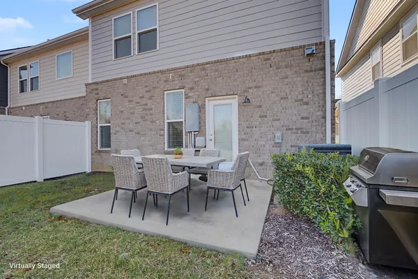 a view of a white house next to a yard and a large tree