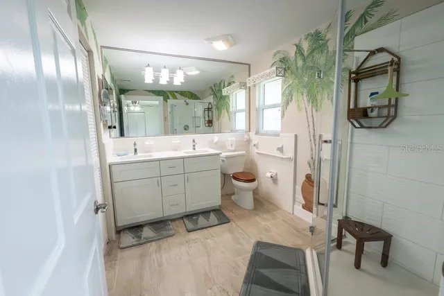 a spacious bathroom with a double vanity sink mirror and toilet