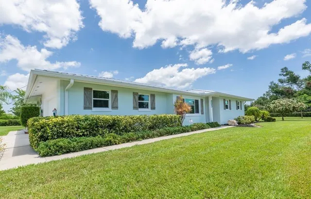 a view of a house with a big yard and potted plants