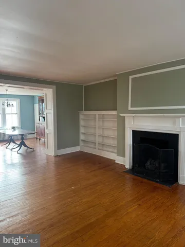 a view of empty room with fireplace and wooden floor