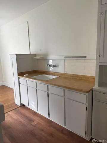 a kitchen with a sink cabinets and wooden floor