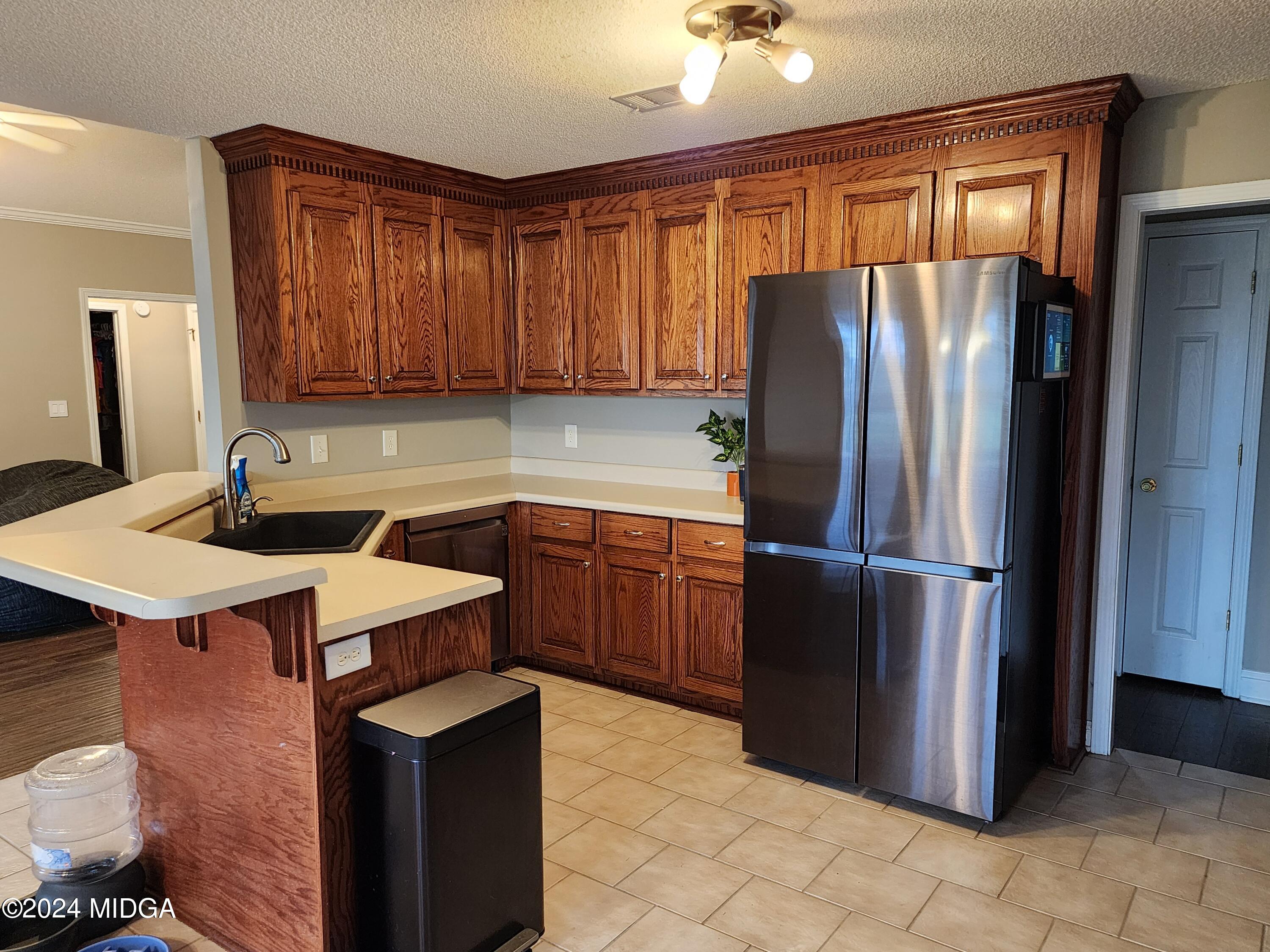 6775 Houston Road Macon, GA 31216 - Photo 9 of 22 a kitchen with a sink a refrigerator and a cabinets