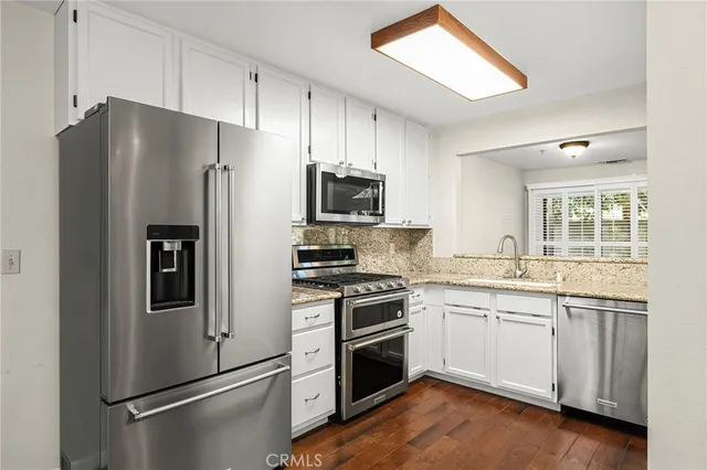 a kitchen with stainless steel appliances a refrigerator stove and microwave