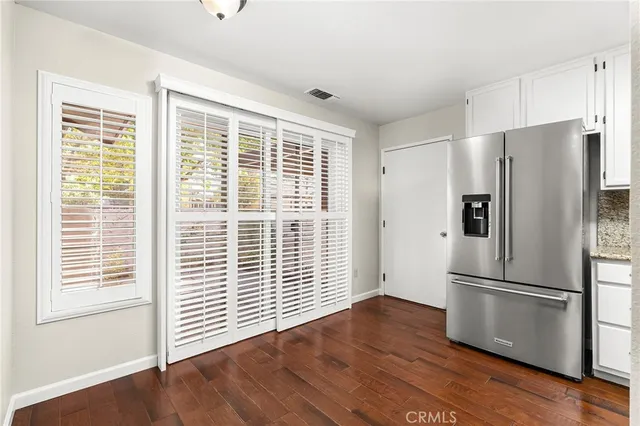 a view of a kitchen with wooden floor and a refrigerator