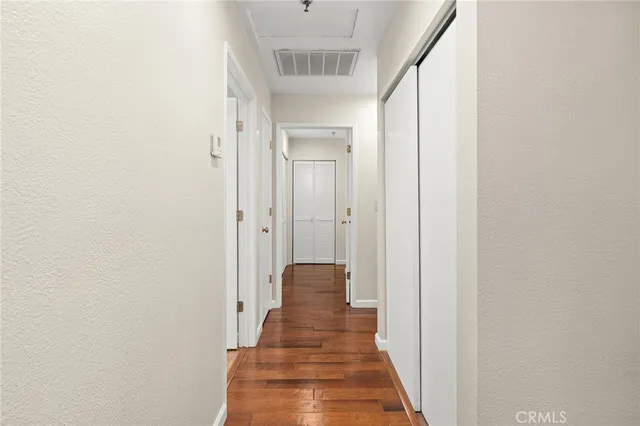 a view of a hallway with wooden floor and entryway