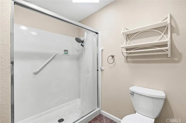 a bathroom with a toilet and a shower