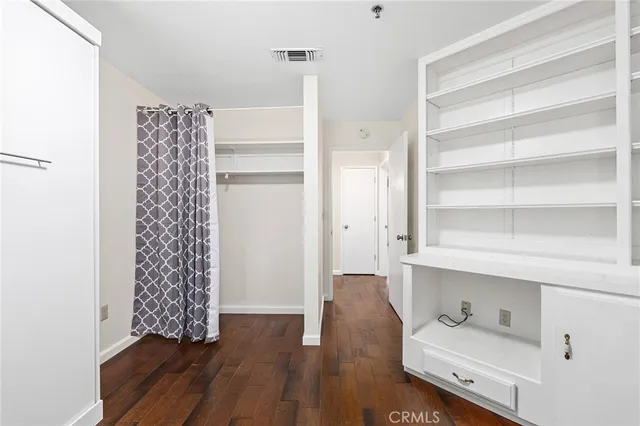 a room with a walk in closet and wooden floor