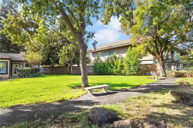 a view of a backyard with table and chairs under an umbrella