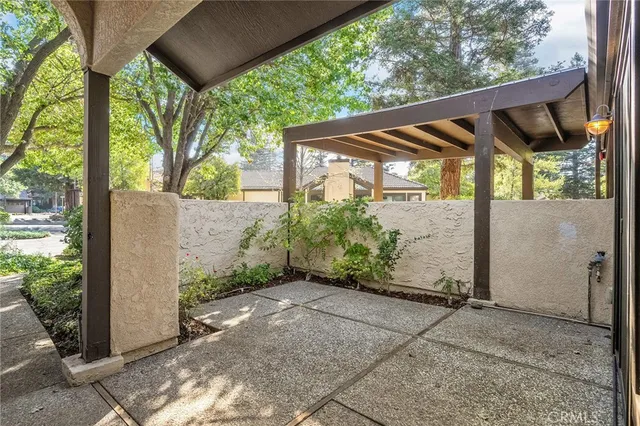 a backyard of a house with large trees and plants