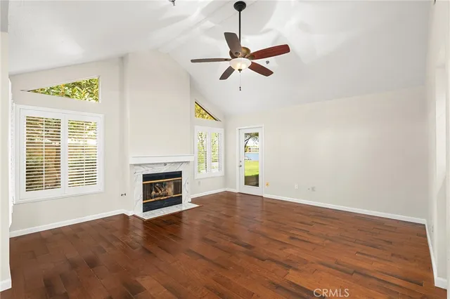 a view of an empty room with a window and fireplace