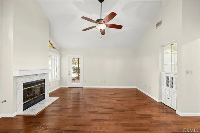 a view of empty room with wooden floor and fireplace
