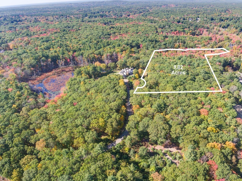 an aerial view of residential houses with outdoor space and trees