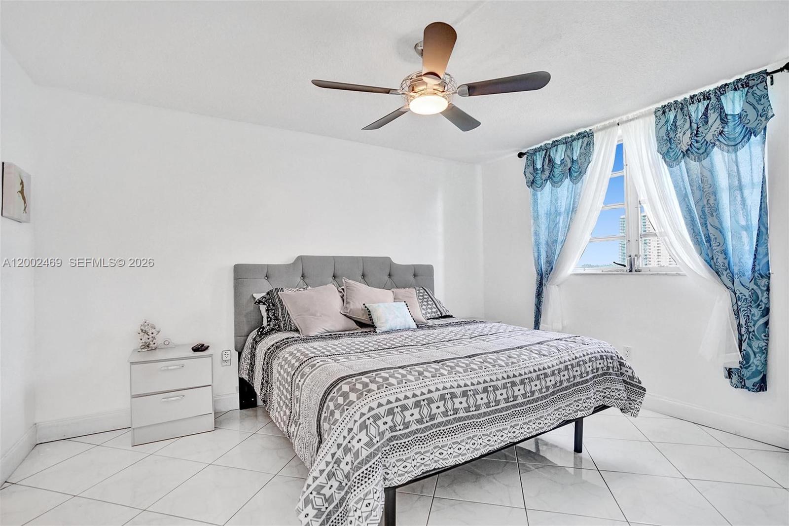 2999 Point E Drive, Unit C511 Aventura, FL 33160 - Photo 18 of 33 a bedroom with a bed and a ceiling fan