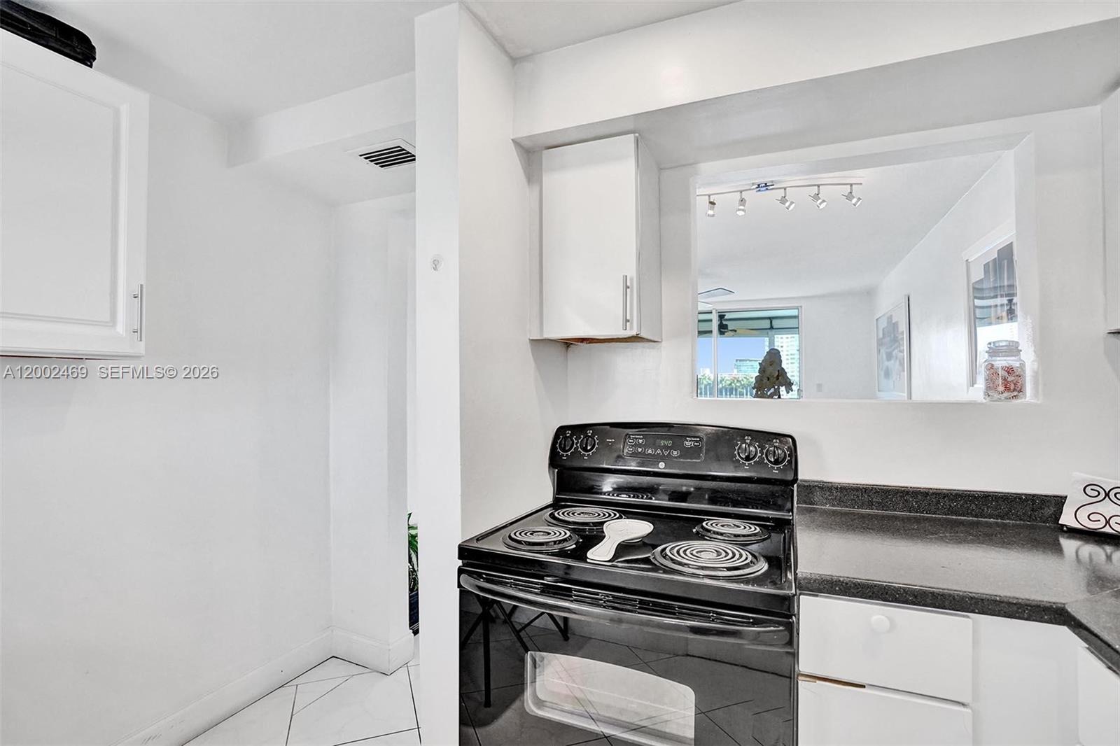2999 Point E Drive, Unit C511 Aventura, FL 33160 - Photo 10 of 33 a kitchen with a stove and a microwave