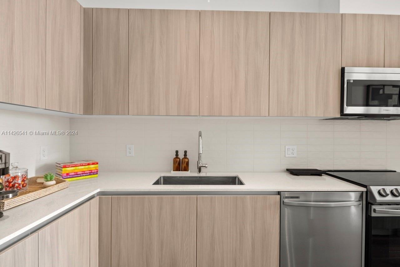 2800 Southwest 27th Terrace, Unit 616 Miami, FL 33133 - Photo 2 of 14 a kitchen with a sink cabinets and stainless steel appliances