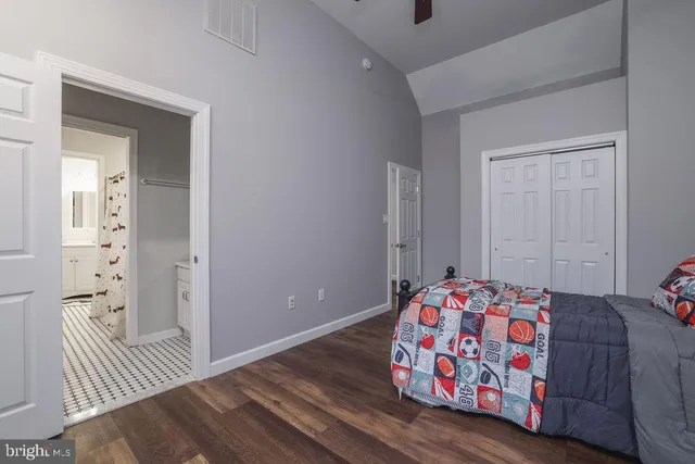 a bedroom with a bed and a lamp on the dresser