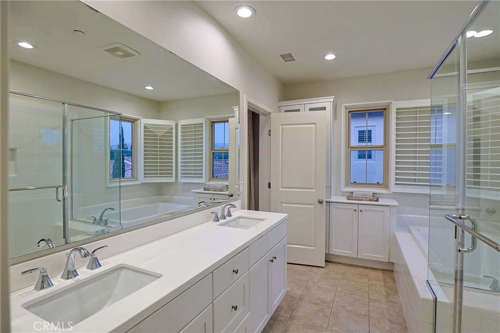 78 Kestrel Irvine, CA 92618 - Photo 15 of 32 a bathroom with a double vanity sink a mirror and a shower