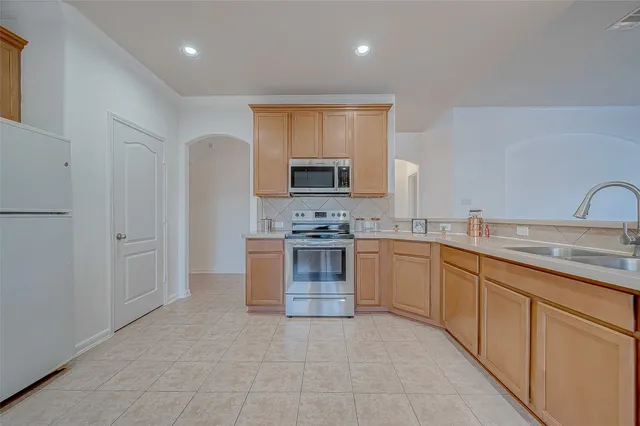 a kitchen with stainless steel appliances granite countertop a stove a sink and a refrigerator