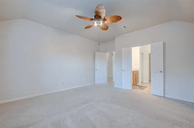 an empty room with ceiling fan and window