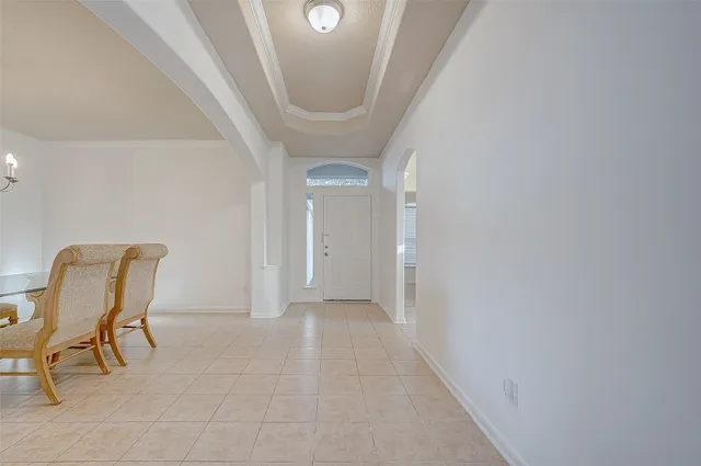 a view of a hallway with chairs and a potted plant on a table