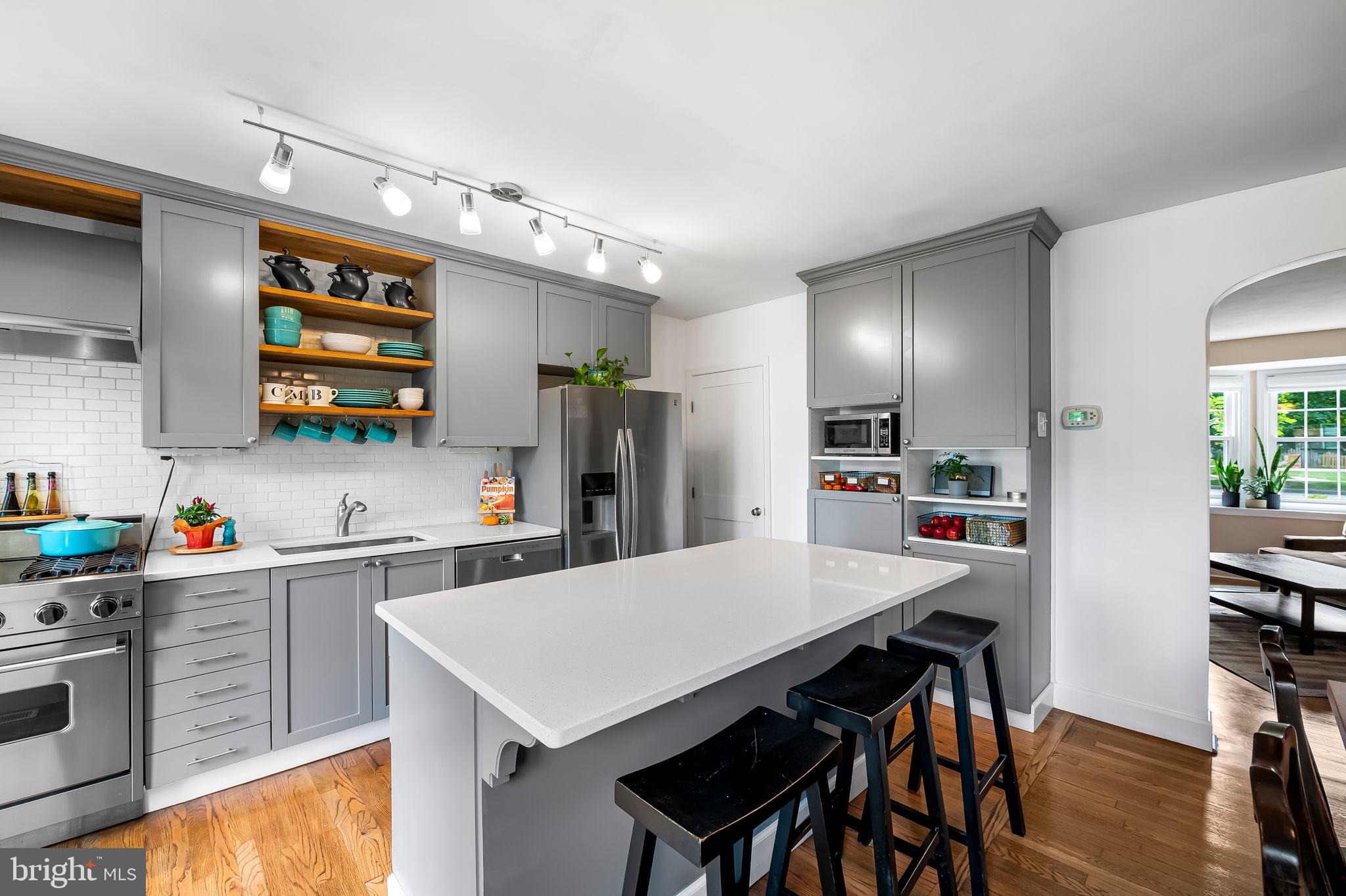 112 Regester Avenue Baltimore, MD 21212 - Photo 12 of 36 a kitchen with a refrigerator a stove a sink dishwasher with a dining table and chairs