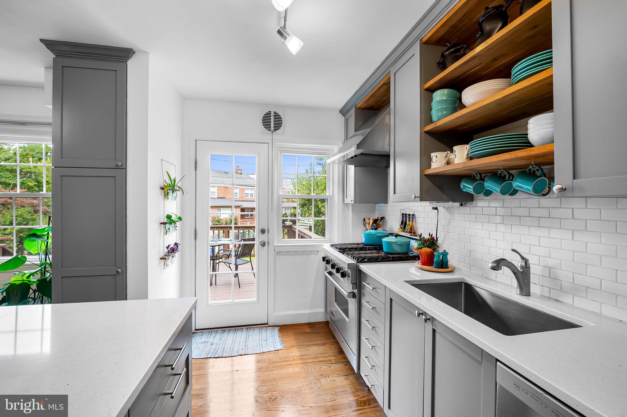 112 Regester Avenue Baltimore, MD 21212 - Photo 14 of 36 a kitchen with stainless steel appliances a sink a stove a refrigerator cabinets and a window