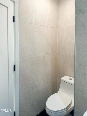 a white toilet sitting next to a white wall