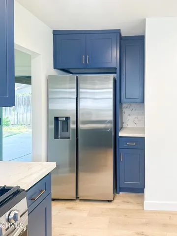 a kitchen with granite countertop a refrigerator and a sink