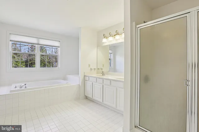 a spacious bathroom with a tub shower sink and mirror