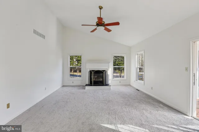 a view of empty room with fireplace and fan