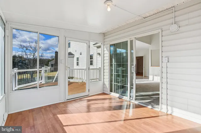 a view of a room with wooden floor and floor to ceiling window
