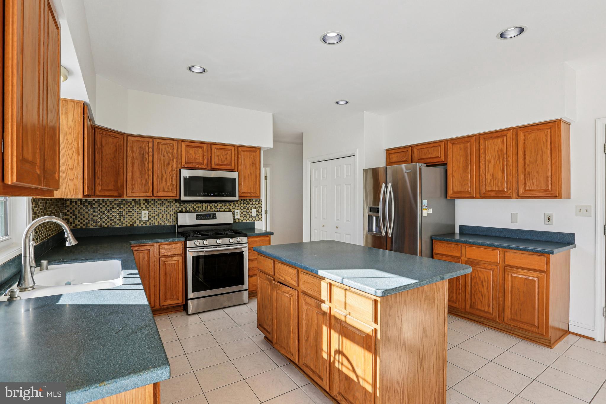3924 Paul Mill Road Ellicott City, MD 21042 - Photo 8 of 51 a kitchen with stainless steel appliances granite countertop a stove refrigerator and a sink