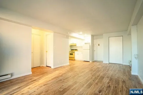 a view of a livingroom with wooden floor and a bathroom