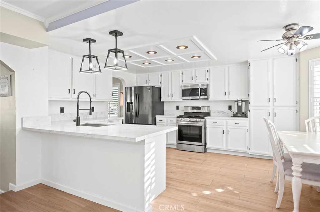 1790 North Encina Avenue Rialto, CA 92376 - Photo 13 of 47 a kitchen with stainless steel appliances kitchen island a white cabinets and a chandelier