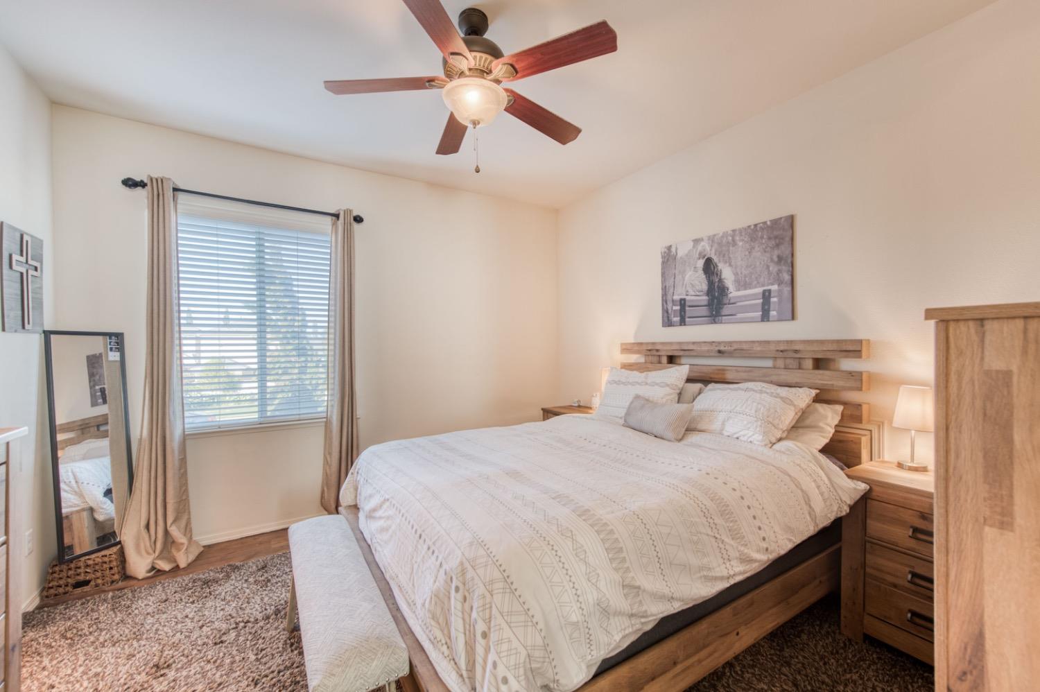 4085 Harlan Ranch Boulevard Clovis, CA 93619 - Photo 15 of 27 a bedroom with a bed and a ceiling fan