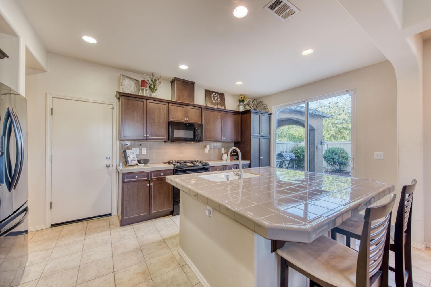 4085 Harlan Ranch Boulevard Clovis, CA 93619 - Photo 18 of 27 a kitchen with stainless steel appliances granite countertop a stove refrigerator sink and cabinets