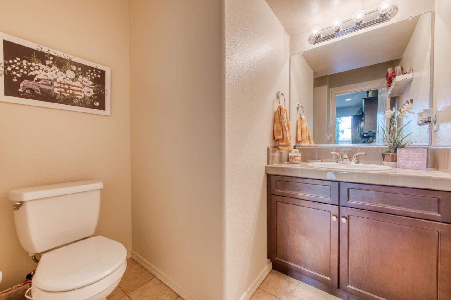 4085 Harlan Ranch Boulevard Clovis, CA 93619 - Photo 20 of 27 a bathroom with a toilet a sink and mirror